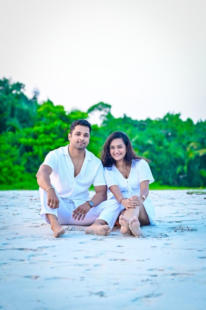 Romantic couple sitting on a beautiful Andaman beach during sunset Couple enjoying a romantic beach walk in Andaman Nicobar Islands